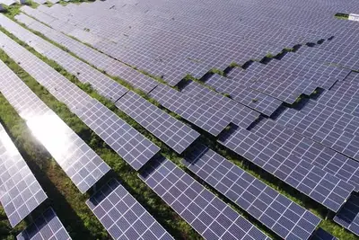 Vue aérienne de rangées de panneaux dans un parc solaire photovoltaïque.