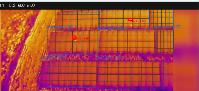 Vue thermique d'un parc solaire analysée par HorusVision&nbsp;: panneaux délimités en bleu avec leur indice de confiance, points chauds encadrés en rouge.